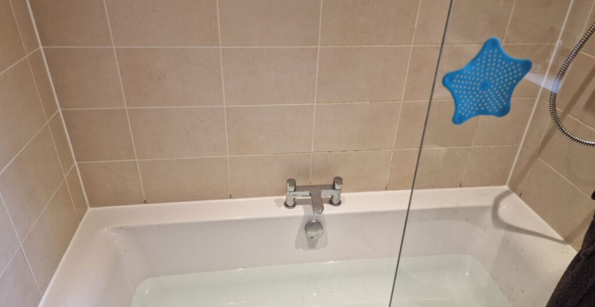 Professional mastic man applying sealant in a bathroom to prevent leaks.