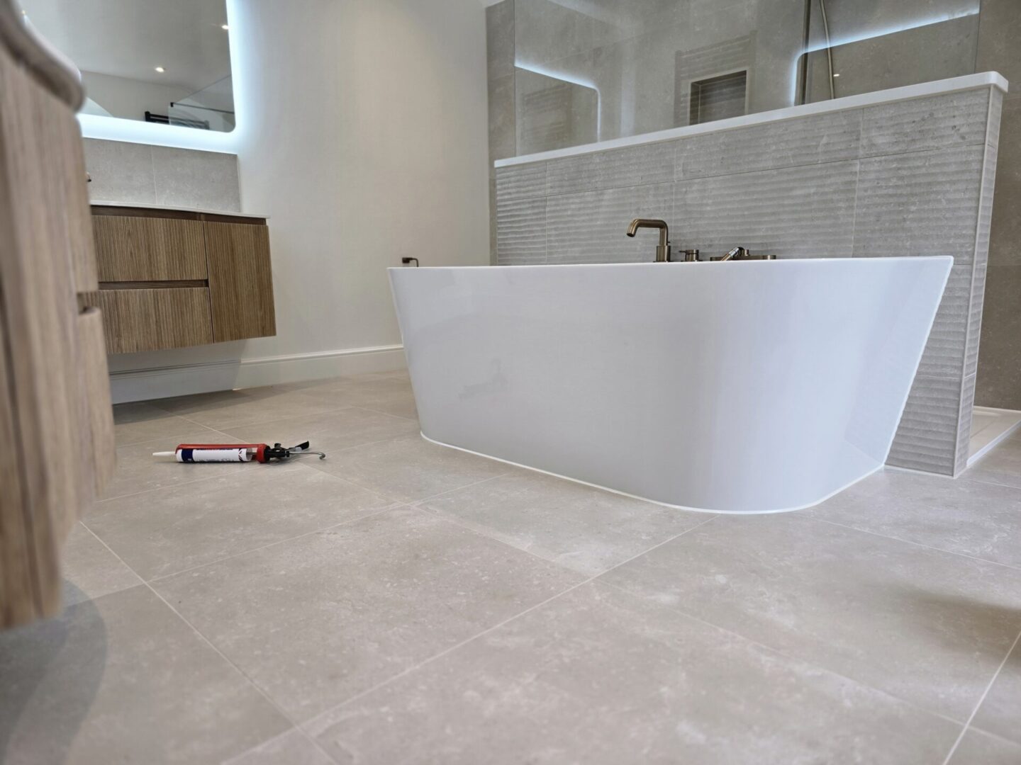 Mastic man applying silicone sealant in a tiled bathroom in Bournemouth